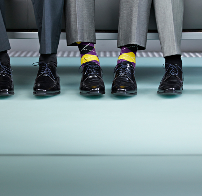 Expert-comptable assis, dont les chaussettes colorées diffèrent de celles de ses voisins.